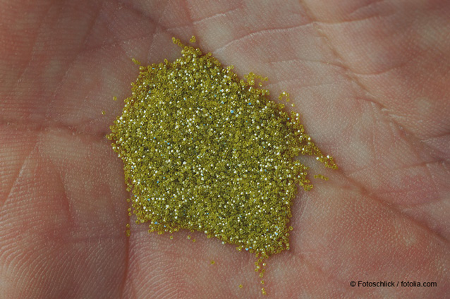 Kleine Ansammlung von gelb-gold farbenen Industriediamanten in der Mitte einer menschlichen Hand. Bildquelle Fotoschlick / fotolia.com