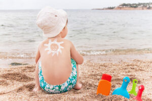 Kind am Strand mit Sonne aus Sonnencreme auf dem Rücken. Bildquelle: MarKord_stock.adobe.com