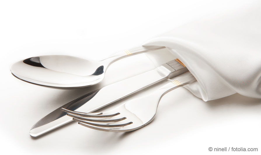 Cutlery set consisting of knife, fork and spoon wrapped in a napkin as an application example for silver