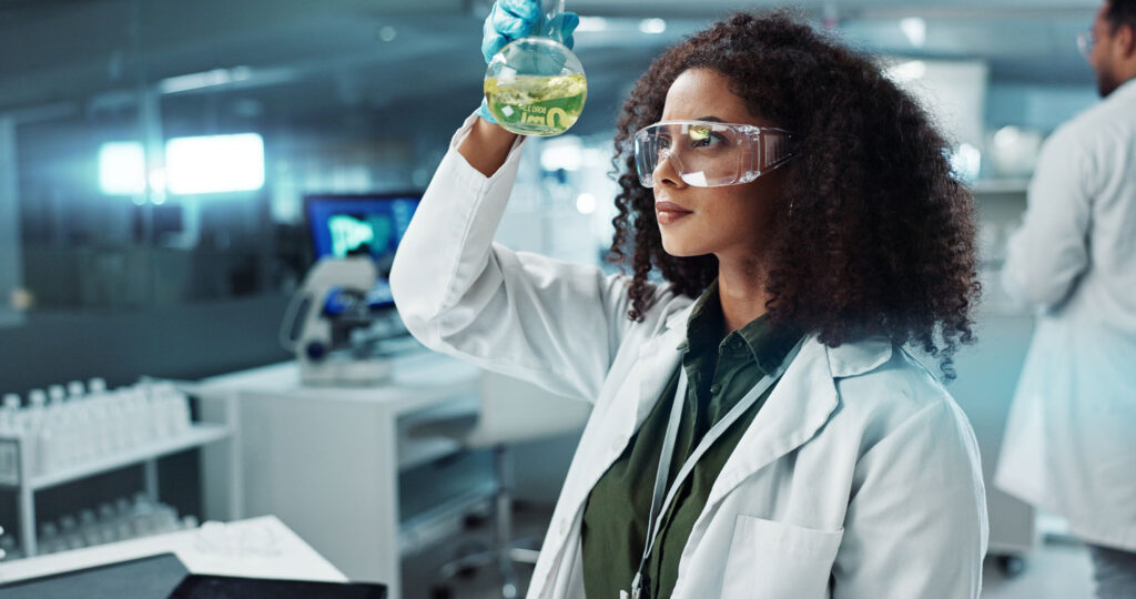 Wissenschaftlerin mit Labormantel, haelt Kolben mit Chemikalie in der Hand. Bildquelle: Coetzee/peopleimages.com -stock.adobe.com