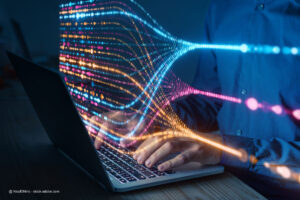 Programmierer, der auf einem Laptop tippt, während im Hintergrund eine farbenfrohe Datenflussvisualisierung zu sehen ist. Bildquelle: NicoElNino